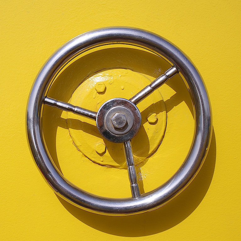 Iron circle wheel on the door of yellow ship
