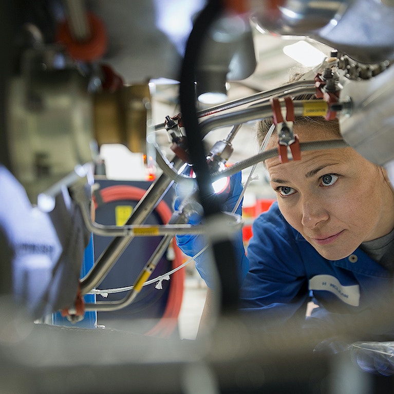 Female helicopter mechanic examining wires