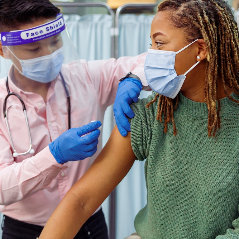 A doctor placing a needle to a patient